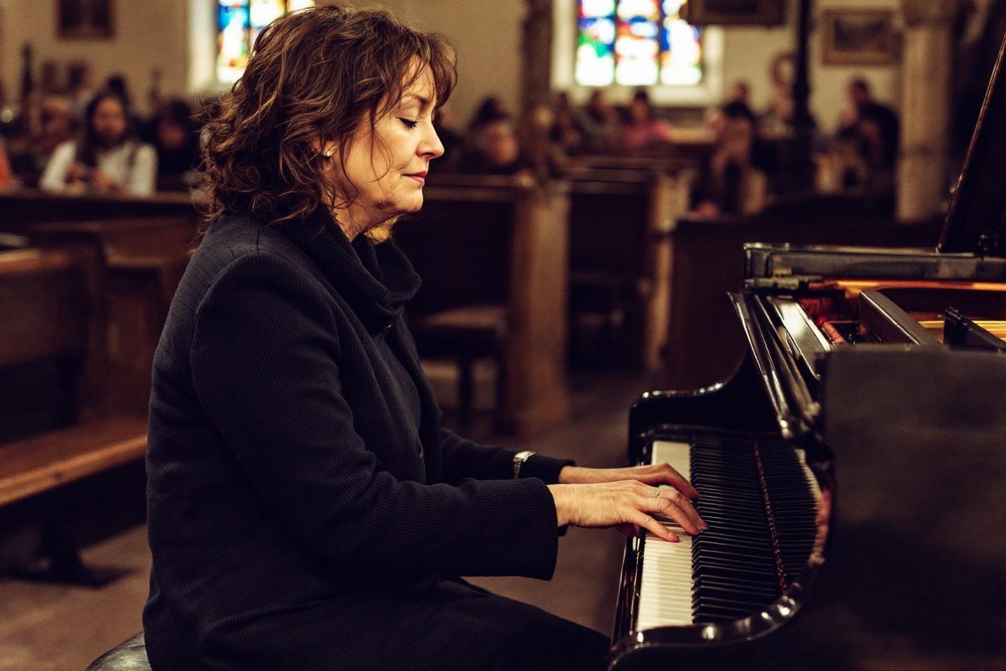 Femme au piano, jouant les yeux ferm&eacute;s dans un lieu sacr&eacute;