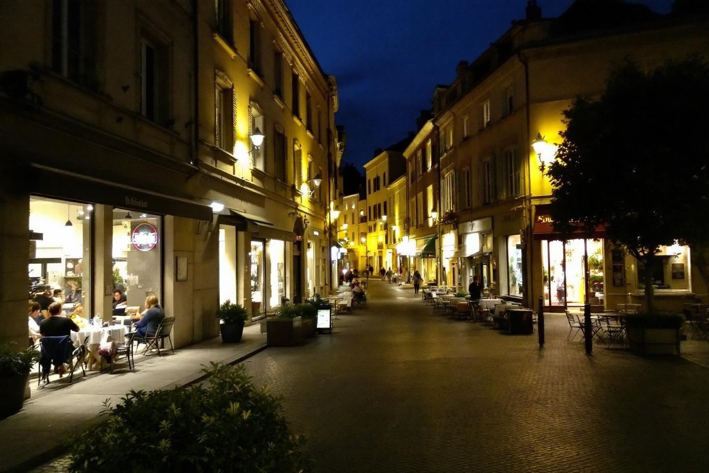 Rue de ville illumin&eacute;e avec caf&eacute;s et architecture traditionnelle