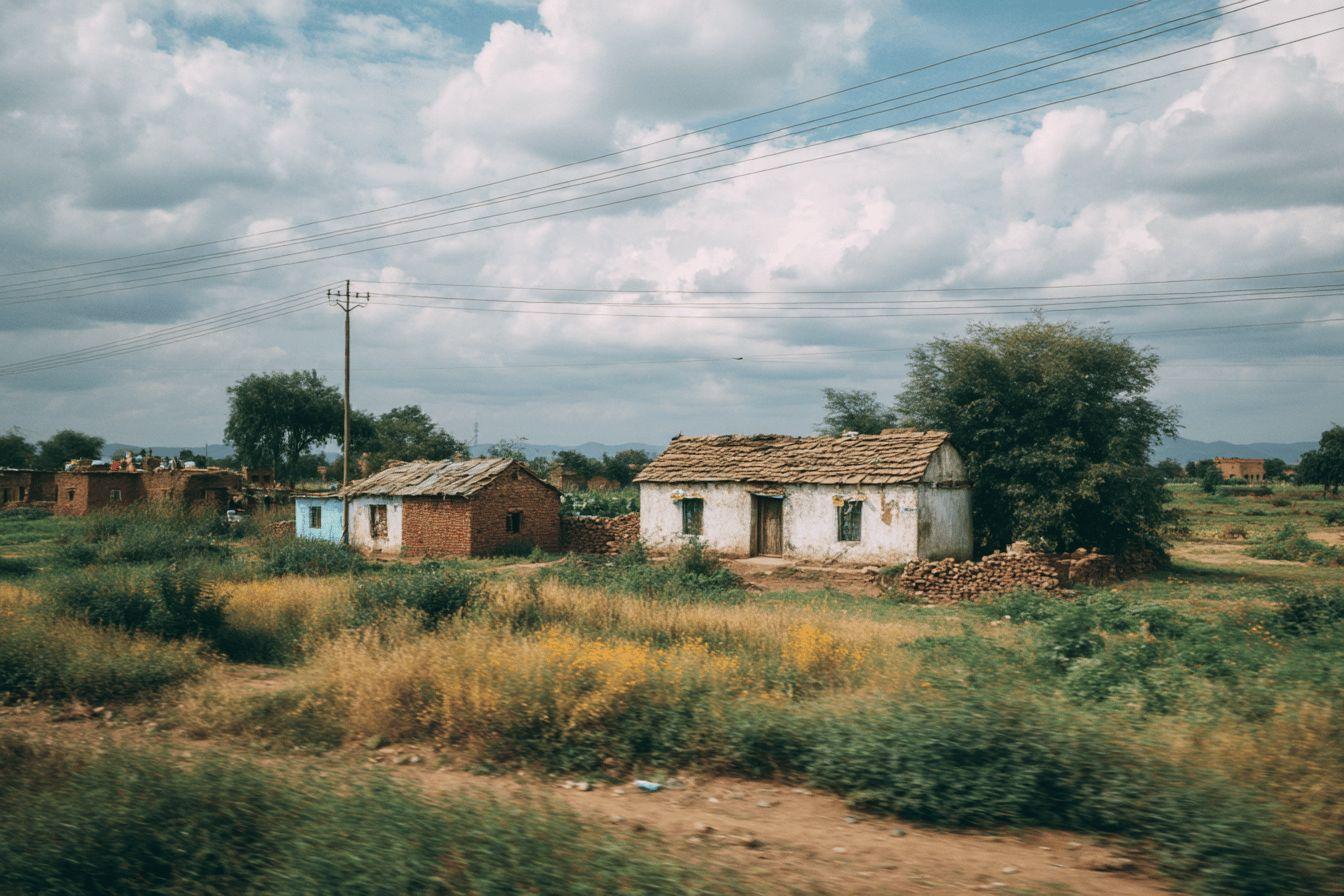 Petites habitations en pierre avec toits de chaume dans campagne verdoyante