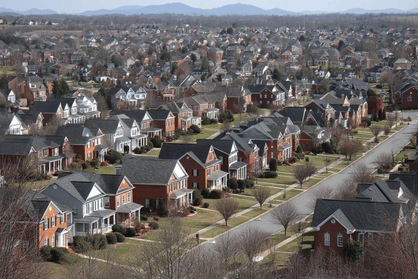 Vue a&eacute;rienne de maisons en briques align&eacute;es avec montagnes en arri&egrave;re-plan