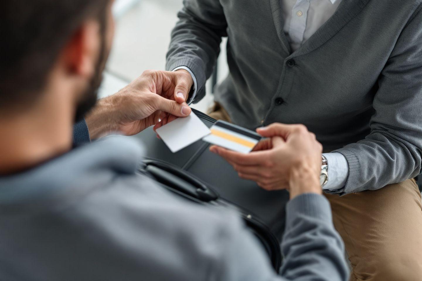 Deux hommes d'affaires en costume &eacute;changeant des cartes de visite