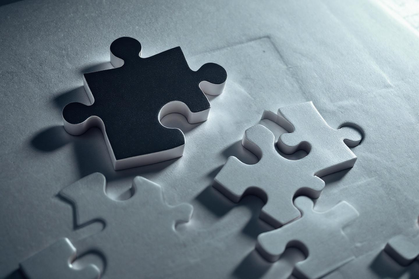 Pi&egrave;ces de puzzle noires et grises, dont une noire manquante
