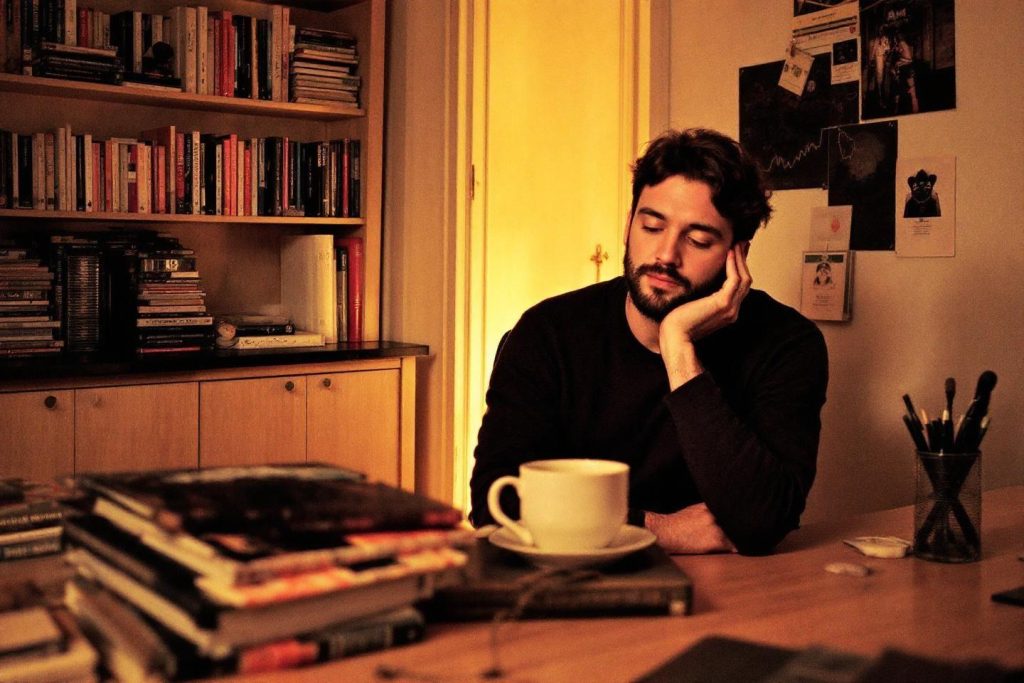 Homme pensif près d'un café et de livres